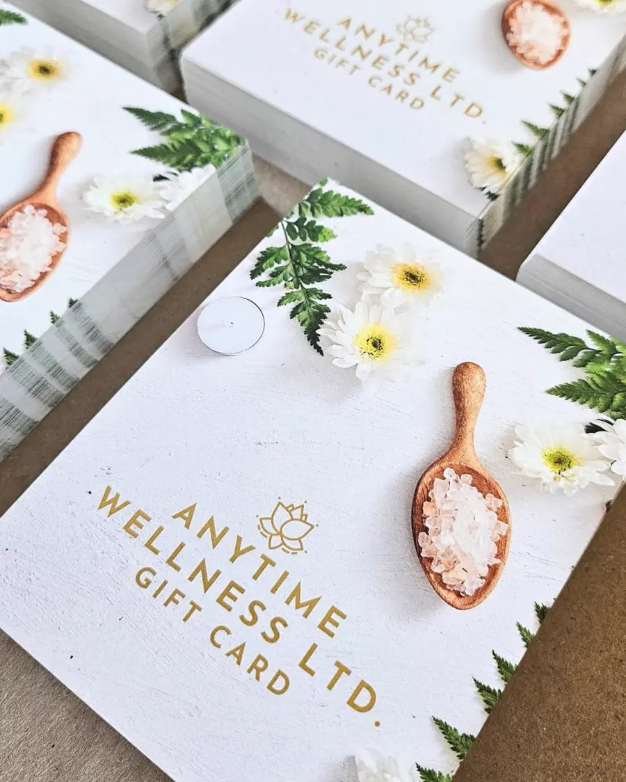 Stacks of white gift cards stamped in gold foil, styled with dried flowers and a wooden salt scoop.